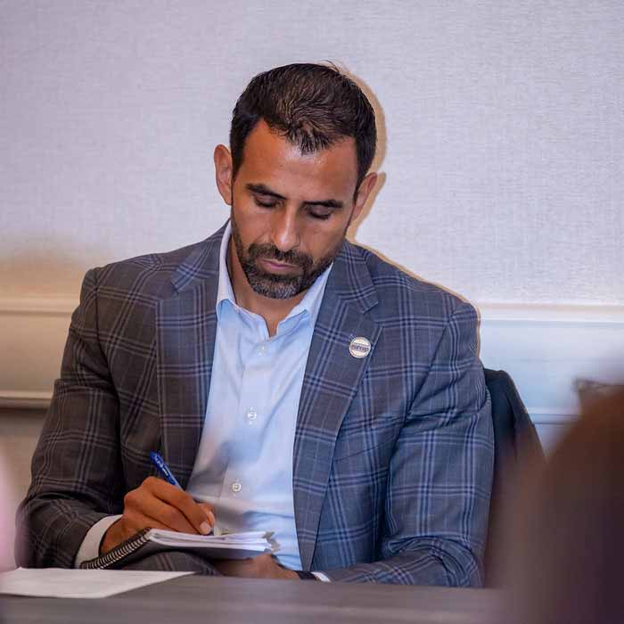 A real estate agent in an educational session making notes on a notepad